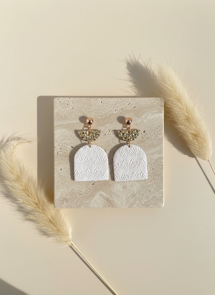 witte oorbellen met gouden accenten en textuur