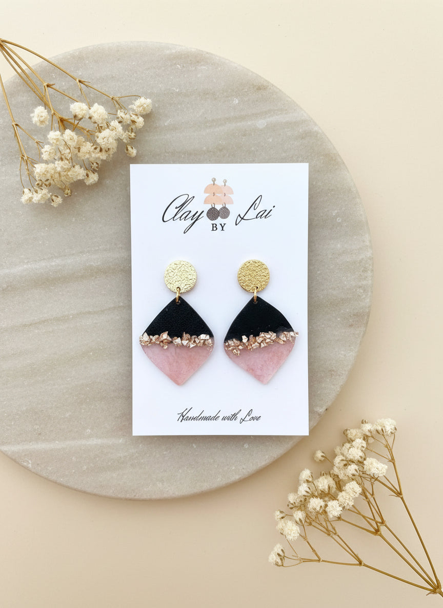 zwart met roze oorbellen met gouden accenten op de oorbel.