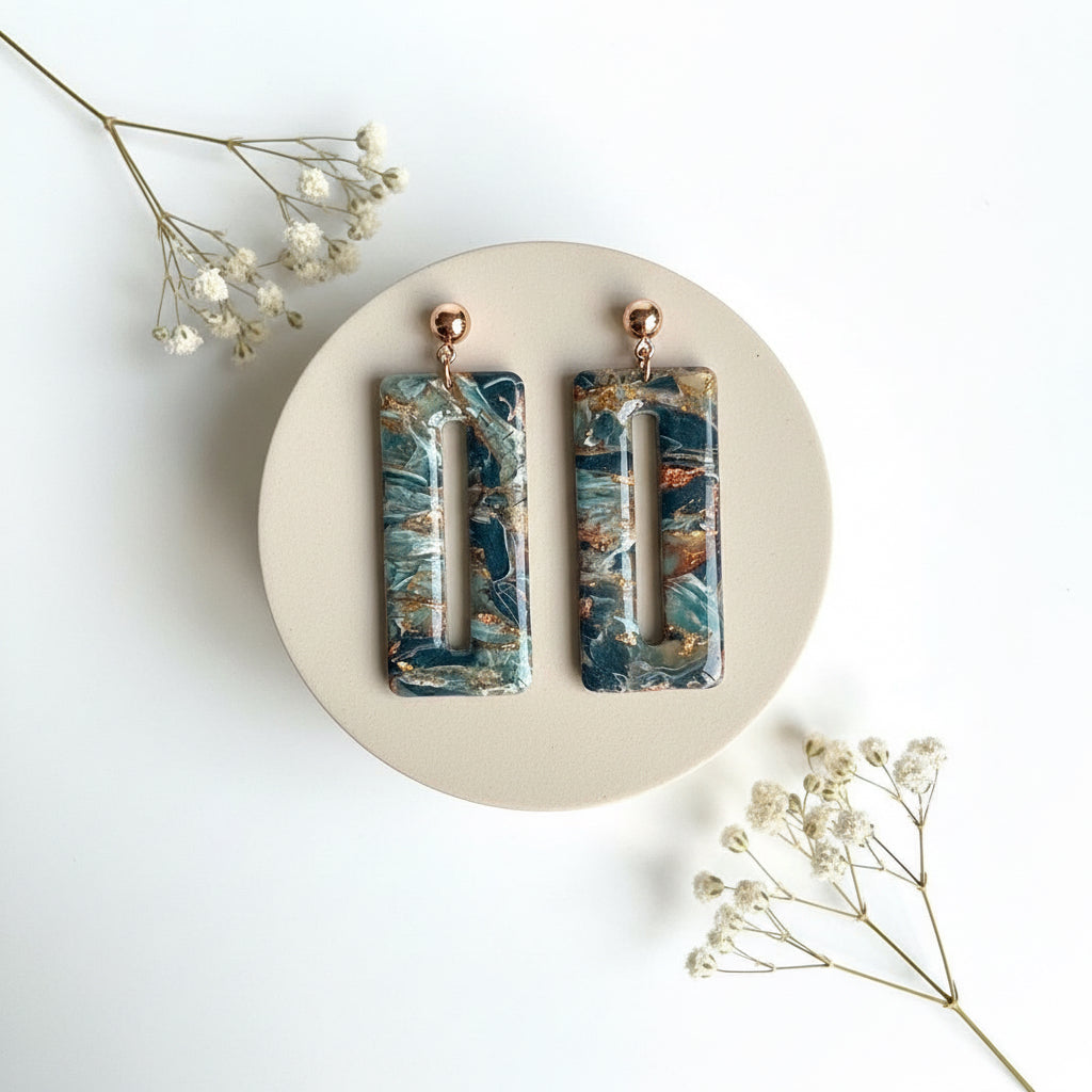 oorbellen met marmer effect van blauw koper en gouden accenten erdoorheen.