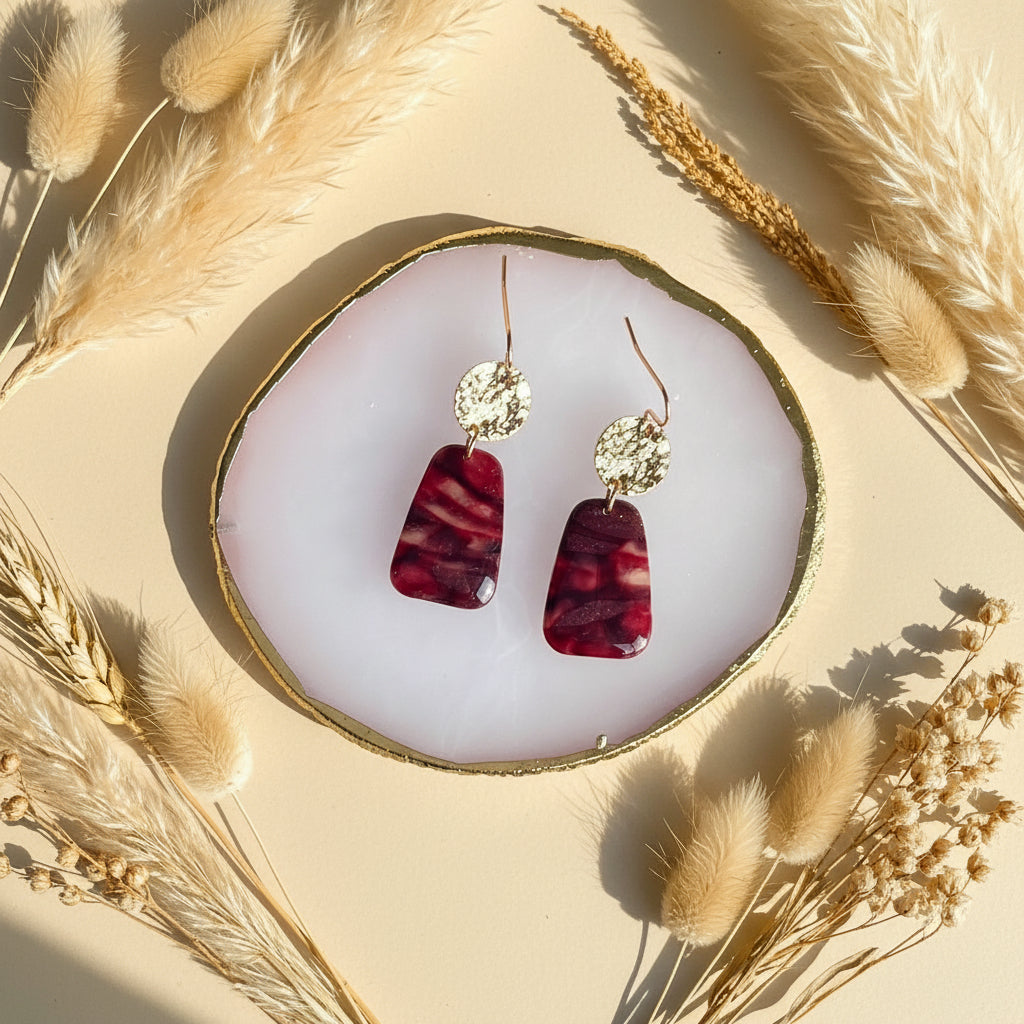 kleine warme marmer oorhangers met goud voor vrouwen, verschillende tinten Bordeaux door elkaar met een klein beetje glitters.
